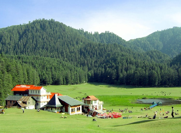 A peaceful green valley in Himachal Pradesh with pine-covered hills and charming budget-friendly accommodations