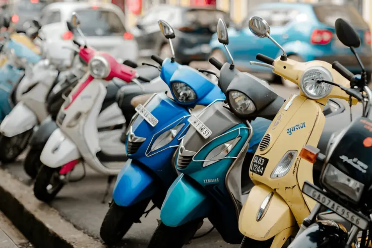 A row of colorful scooters parked on a street, representing an affordable transportation option for budget travelers in Goa