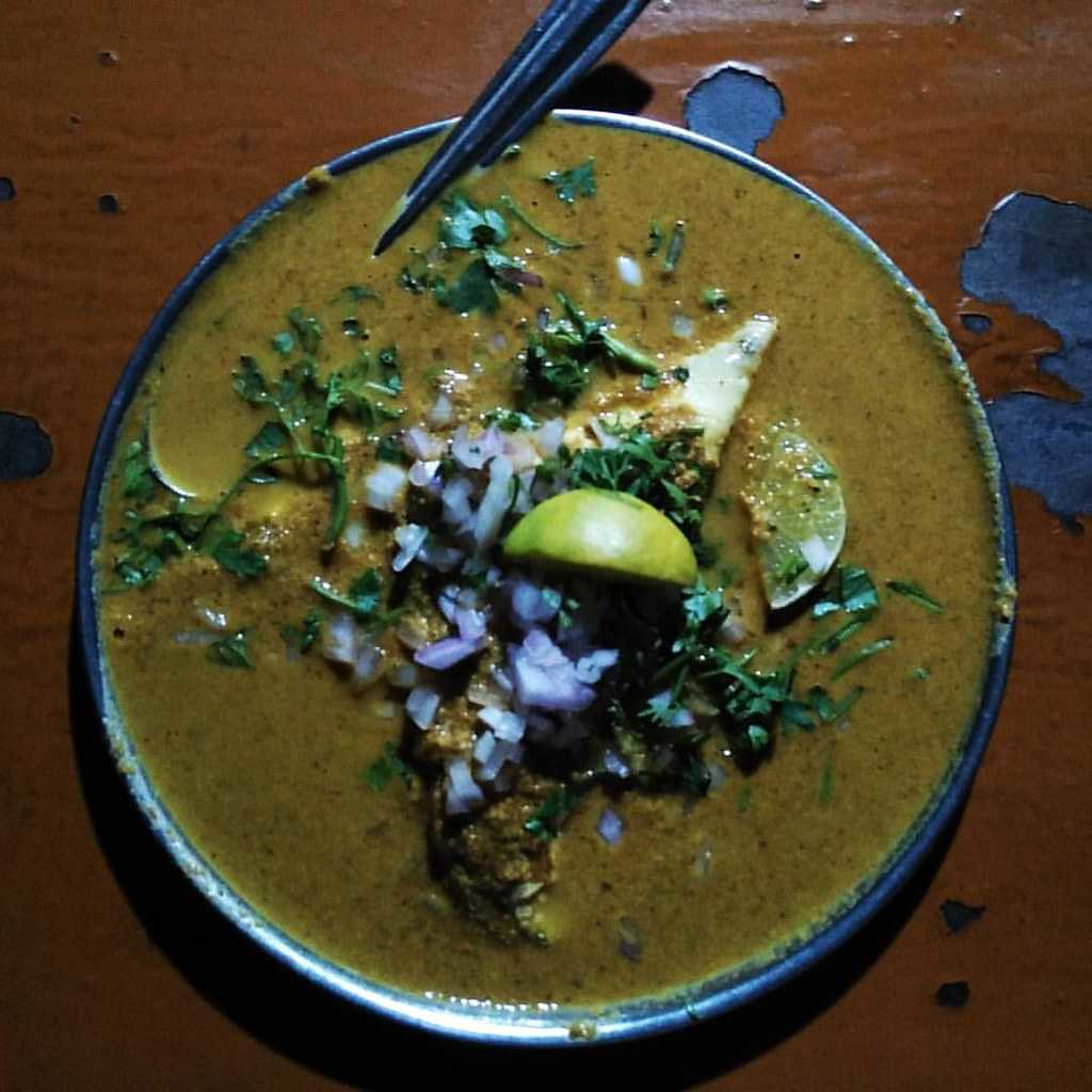 Authentic Goan curry garnished with fresh herbs and lemon, showcasing local street food flavors
