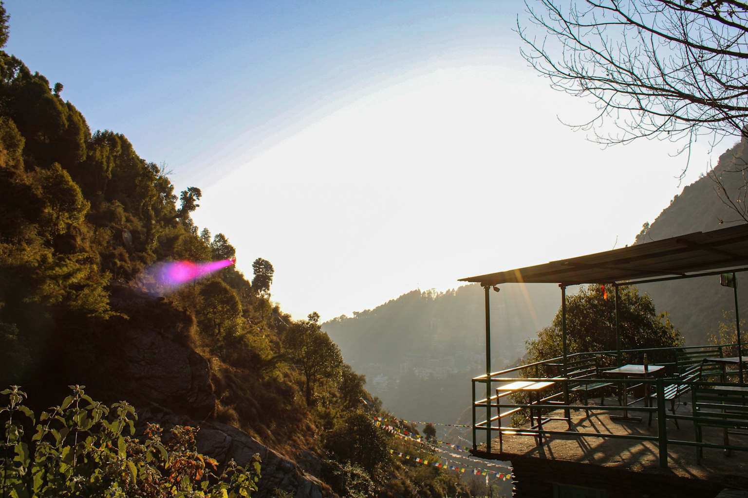 An outdoor seating area with a scenic view of hills and trees, ideal for budget-friendly weekend trips in India