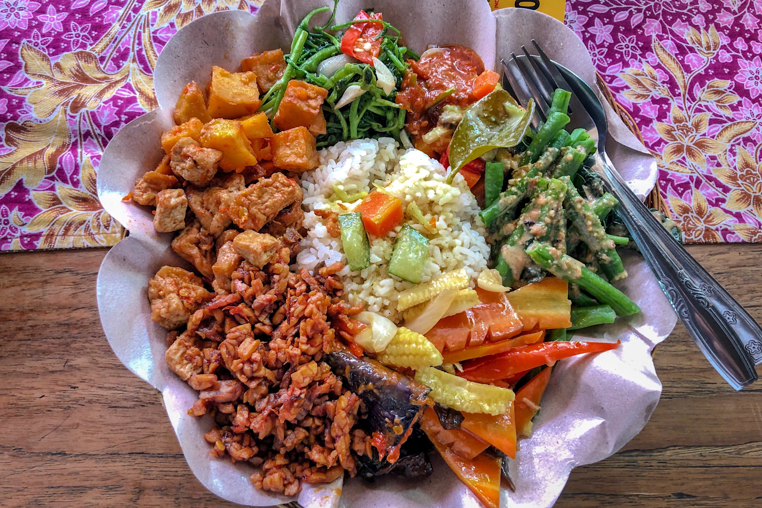 A typical budget-friendly Indonesian meal featuring rice, tempeh, and assorted vegetables served at a Bali warung