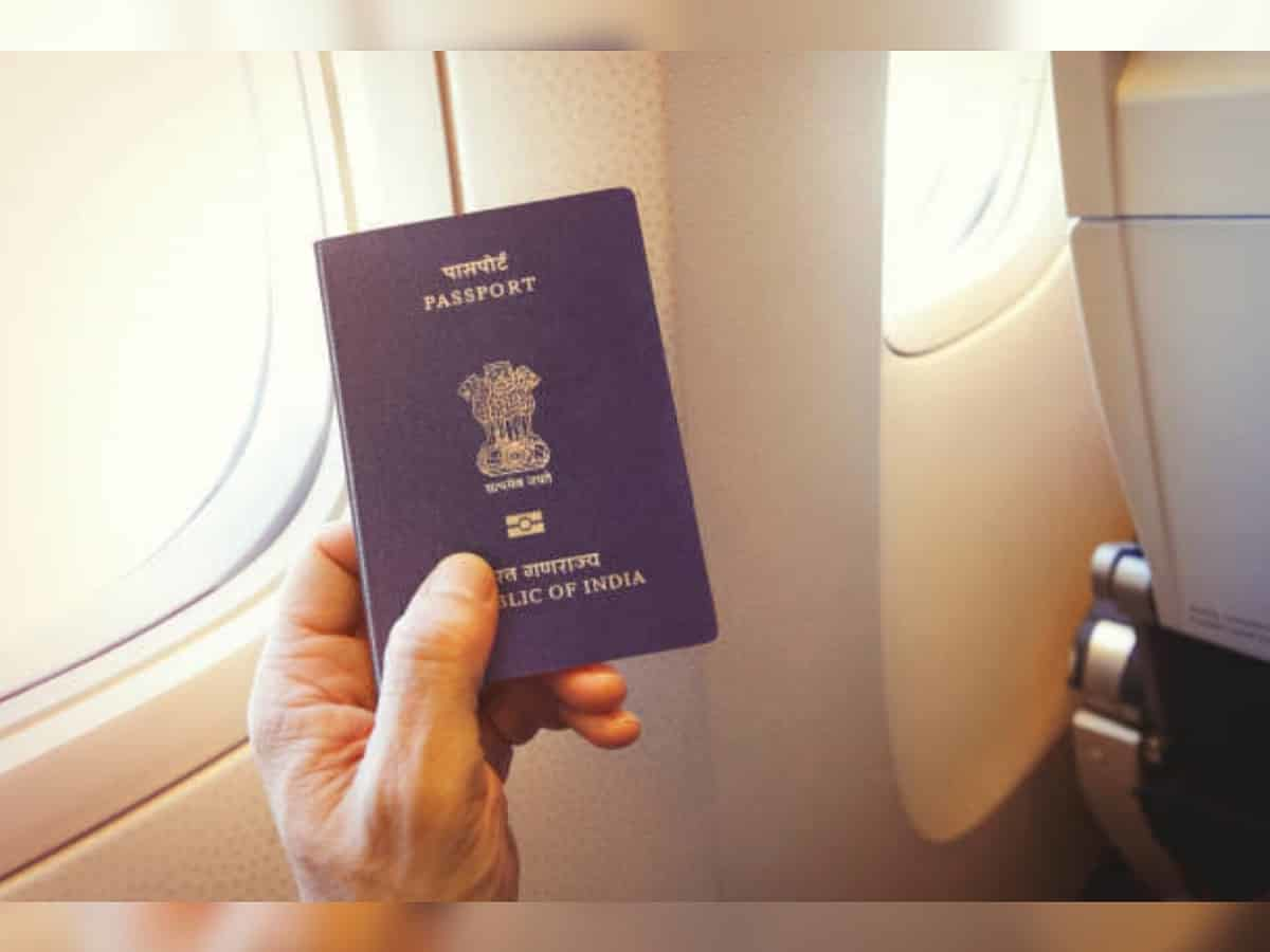 Indian passport held inside an airplane cabin, symbolizing international travel and visa documentation for Indian travelers