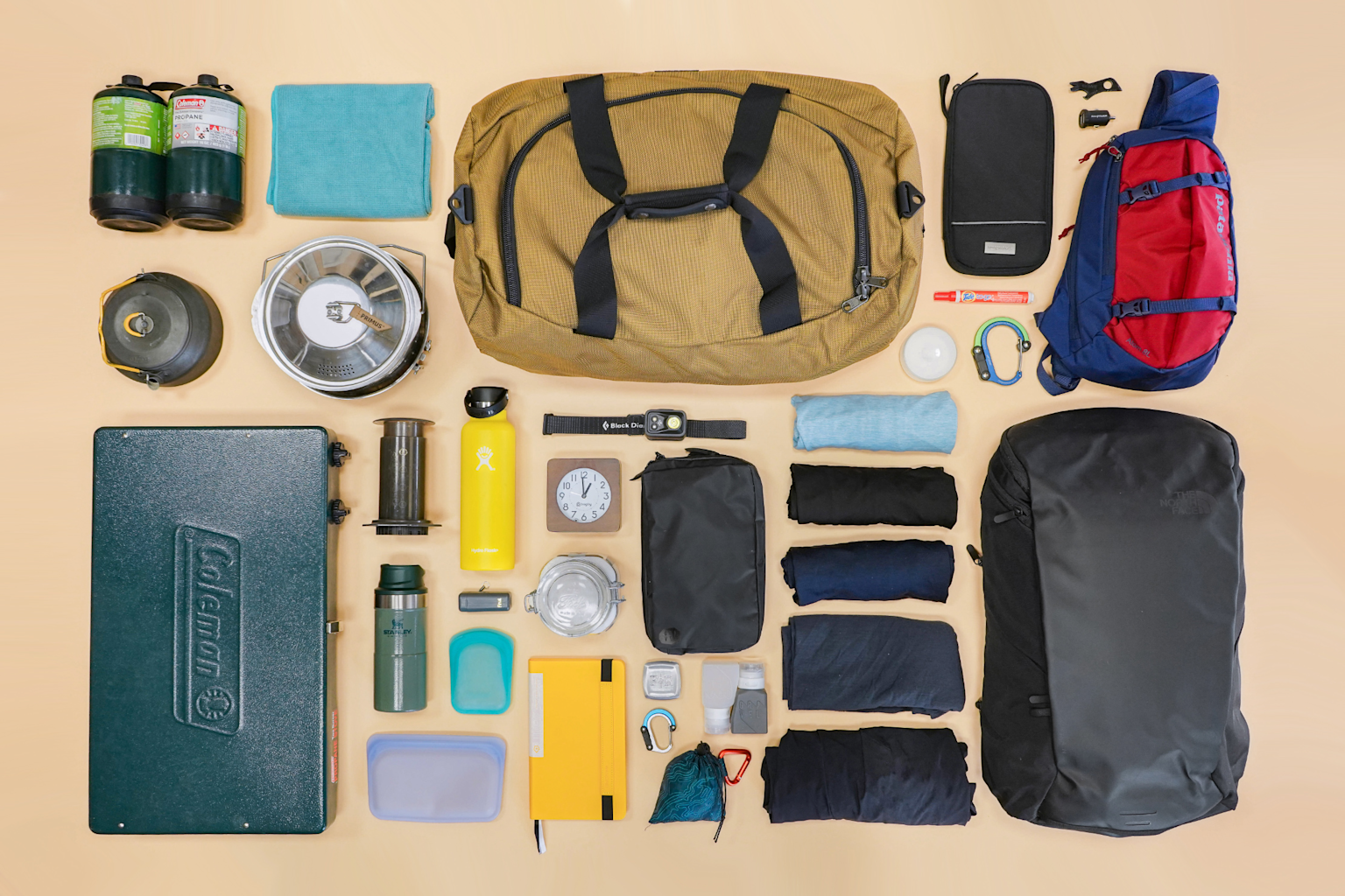 Essential compact travel gear and clothing neatly arranged for a budget weekend trip packing list