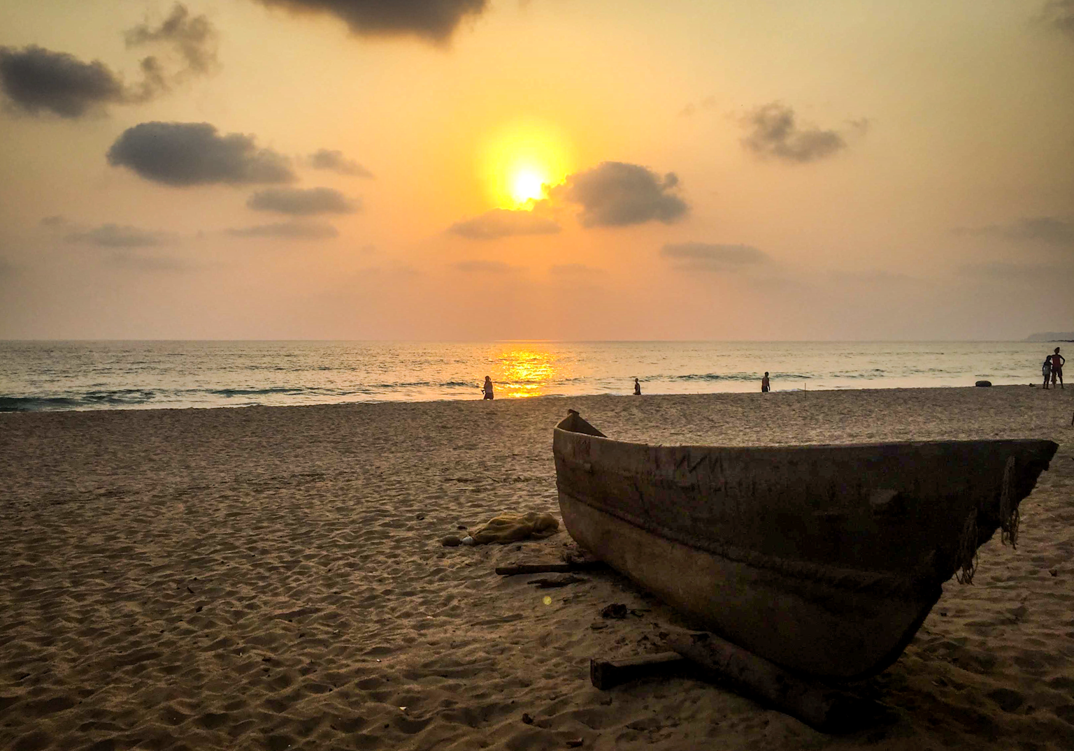 Sunset at a peaceful Goa beach with a wooden boat on the sand, evoking solitude and calm perfect for solo travelers