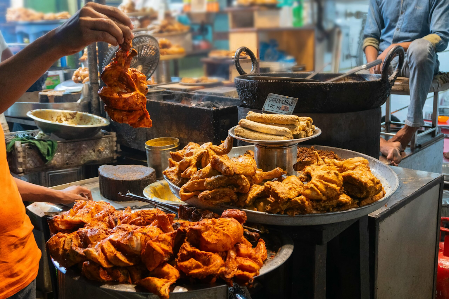 Indian street food stall serving budget-friendly fried chicken and chicken kebabs, illustrating affordable local dining experiences