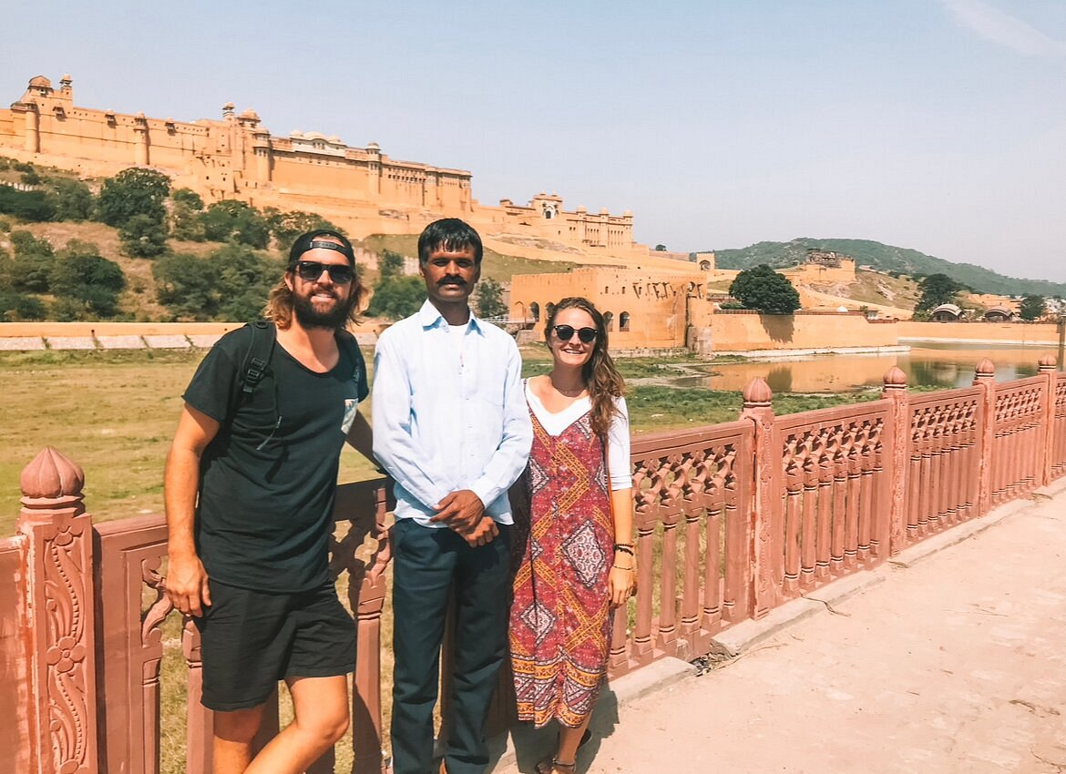 Tourists posing in front of the Amber Fort, a major heritage site in Rajasthan, reflecting cultural touring experiences