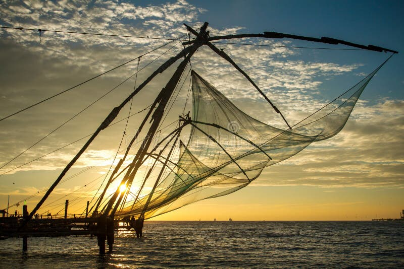 Chinese fishing nets at Fort Kochi silhouetted against a colorful sunrise